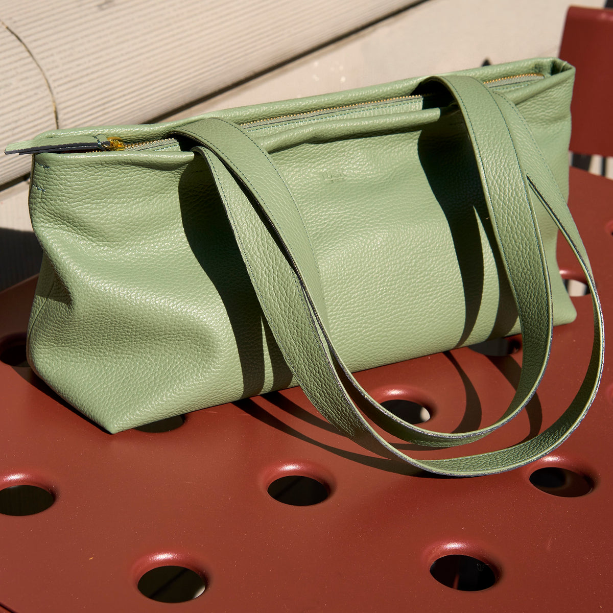 Sage green Anaya zip-top leather tote on a chair in sunlight - SAGE